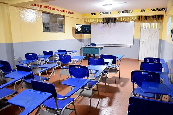 Aula de bachillerato con pupitres y televisor