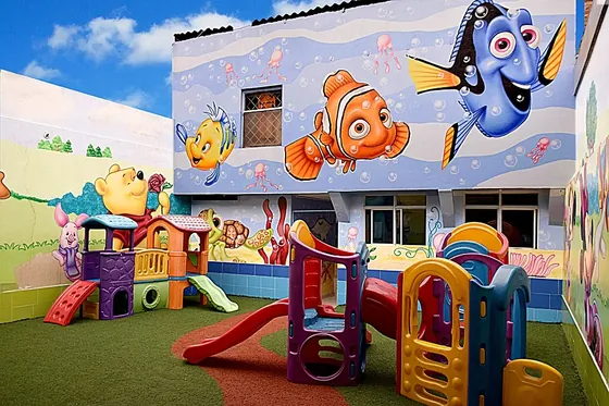 Parque de juegos de preescolar con toboganes y murales infantiles
