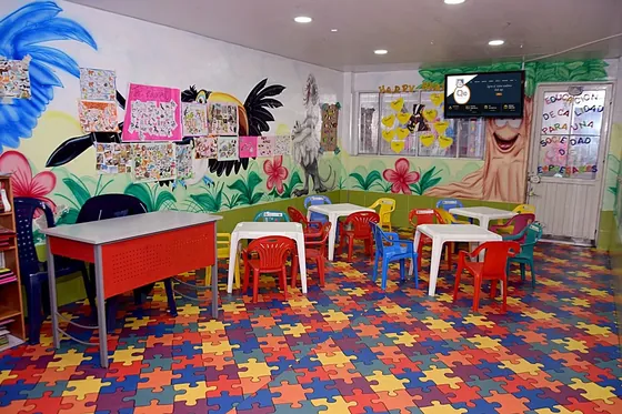 Aula de preescolar con mesas de colores y murales