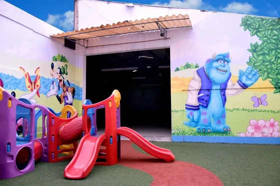 Zona de juegos de preescolar con tobogán y mural