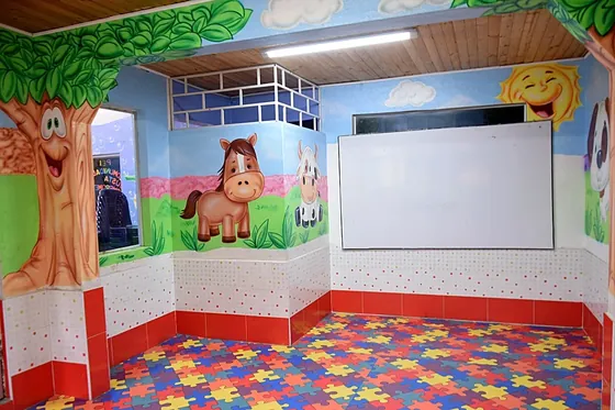 Aula de preescolar con mural de la granja y piso didáctico