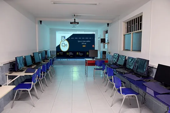Salón audiovisual con proyector y puestos de trabajo